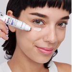 Mujer-aplicandose-la-crema-para-contorno-de-ojos-de-la-li-nea-Skin-First